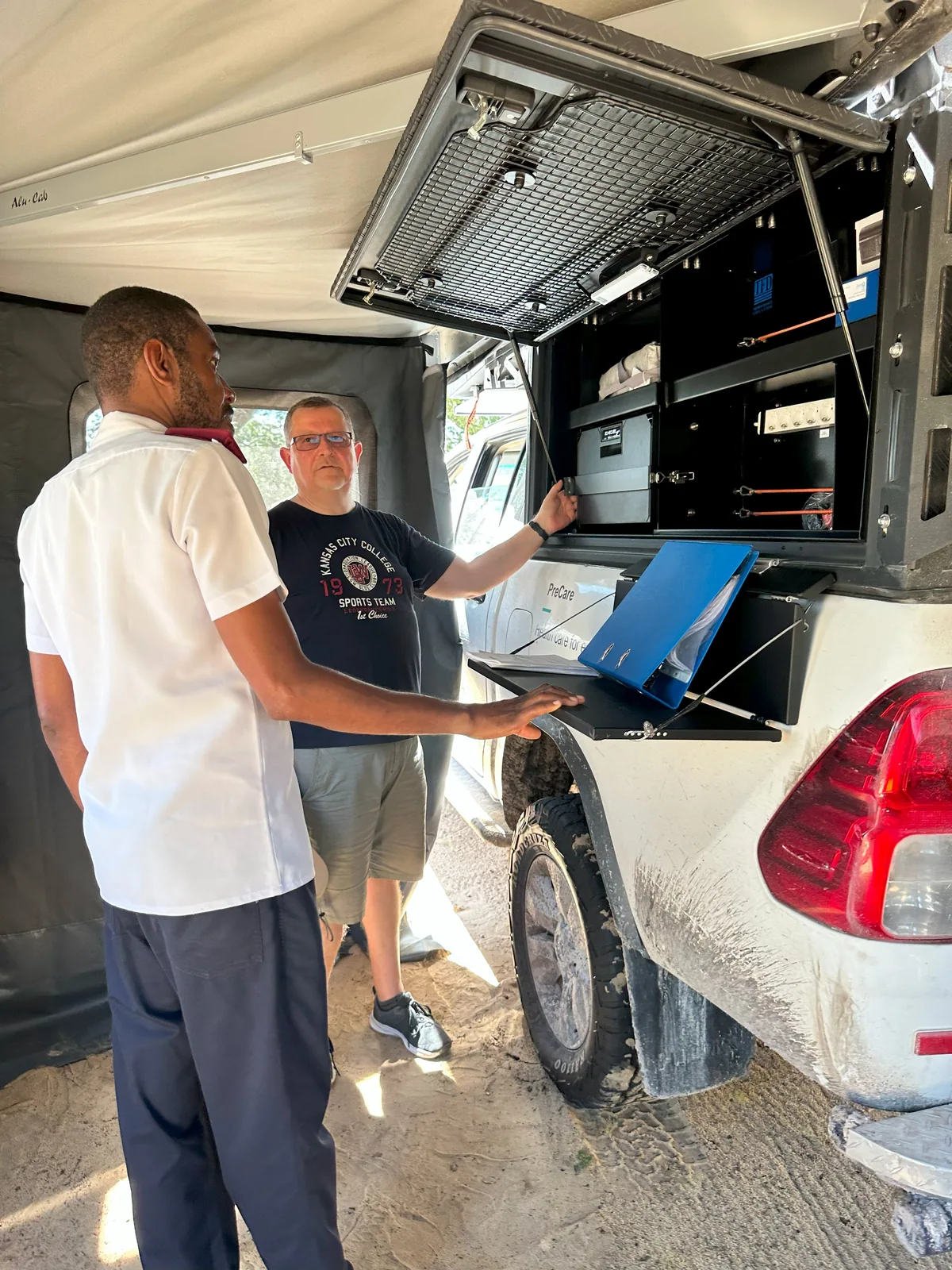 Two people discussing equipment inside the PreCare mobile health platform